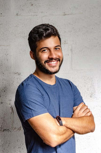 Home Portrait of a happy man with arms crossed, exuding confidence and friendliness.